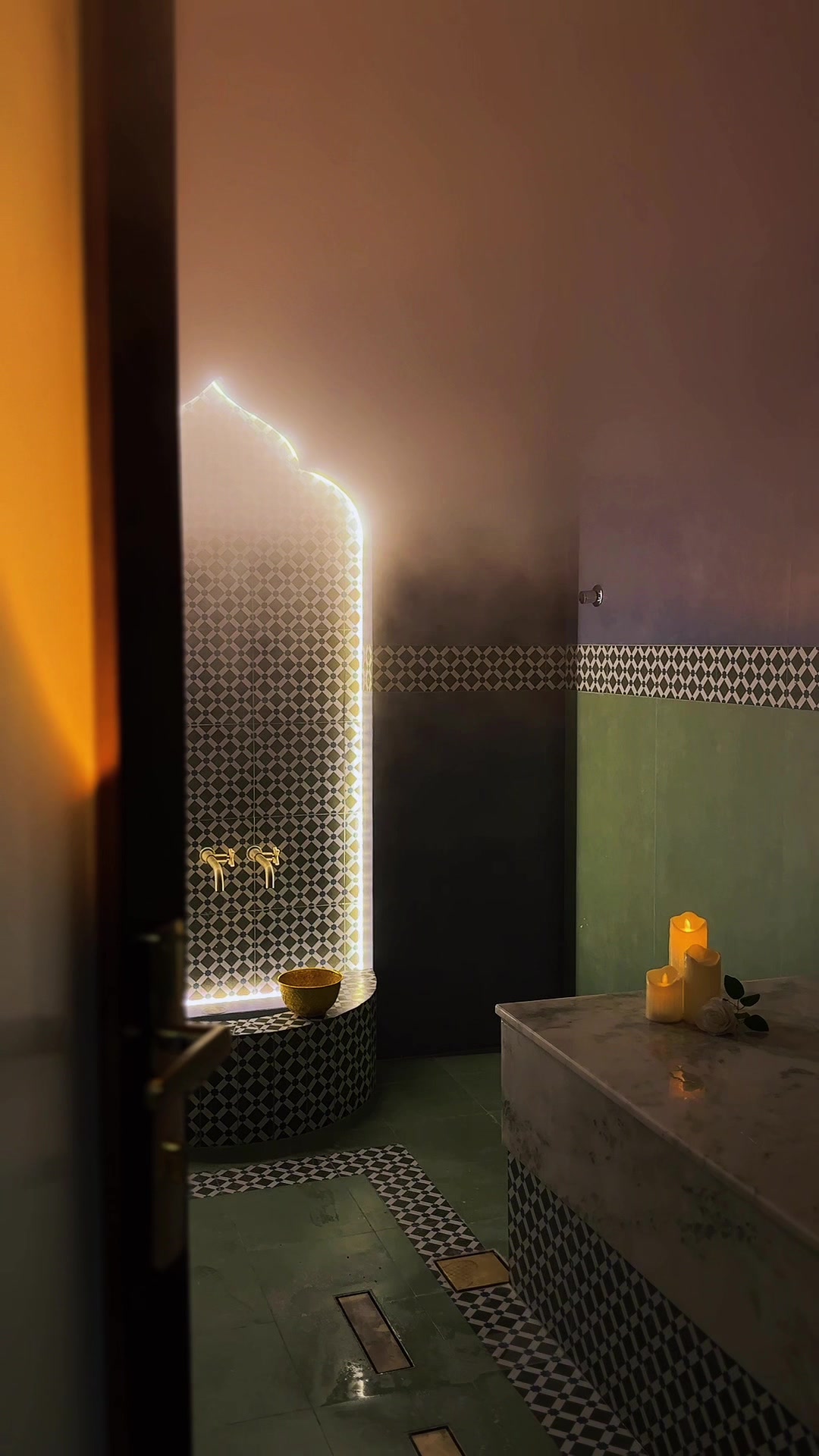 The lit arch, brass taps and candlelit marble of the hammam